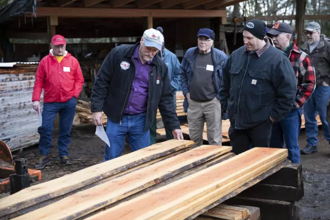 Participants at small sawmilling workshop looking at lumber
